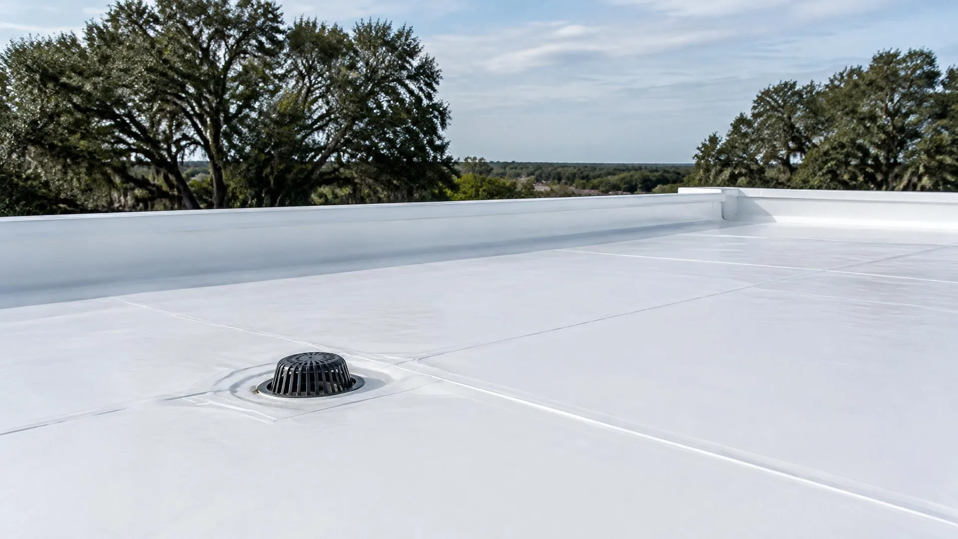 White TPO membrane on a low-slope roof with welded seams and a drain