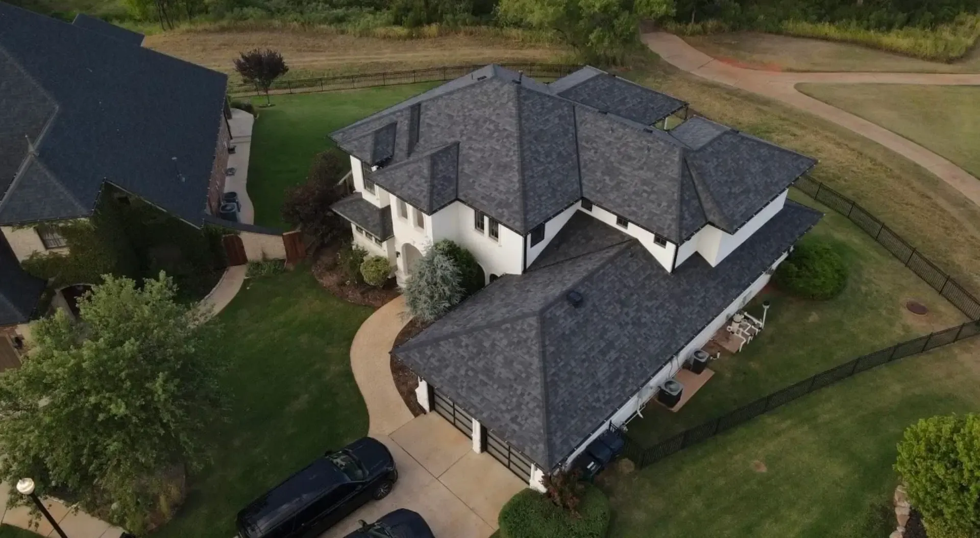 Aerial view of a two-story home with a new charcoal shingle roof